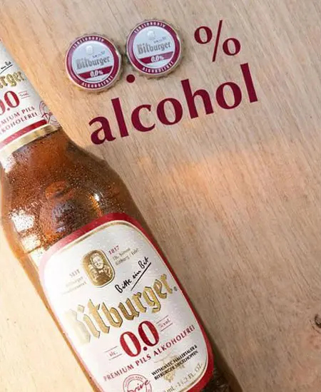 Cerveza de Bitburger 0.0 x 330ml plano medio con dos tapas y la palabra alcohol