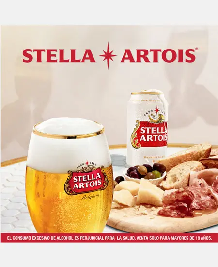 Foto de copa de cerveza con plato de comida y cerveza en lata de Stella Artois Lata Sixpack x 269ML