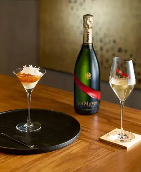 Mumm Cordon Rouge fotografia con copa y coctel en una mesa de madera