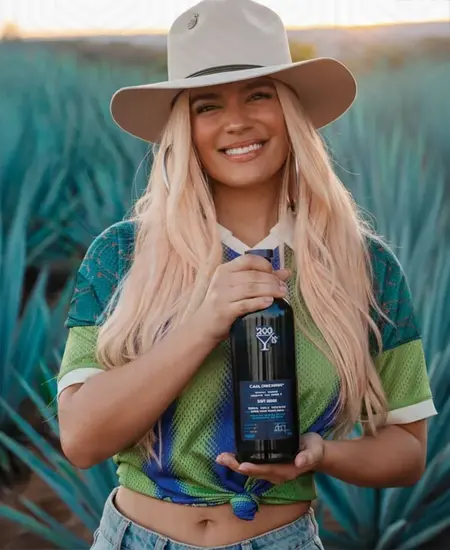 Karol G con Tequila 200 copas en campo de agave